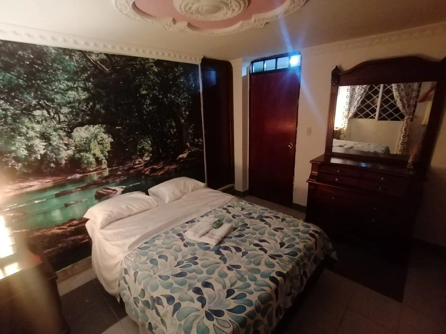Habitación con mural de bosque y río en el Hostal Campestre El Galeno