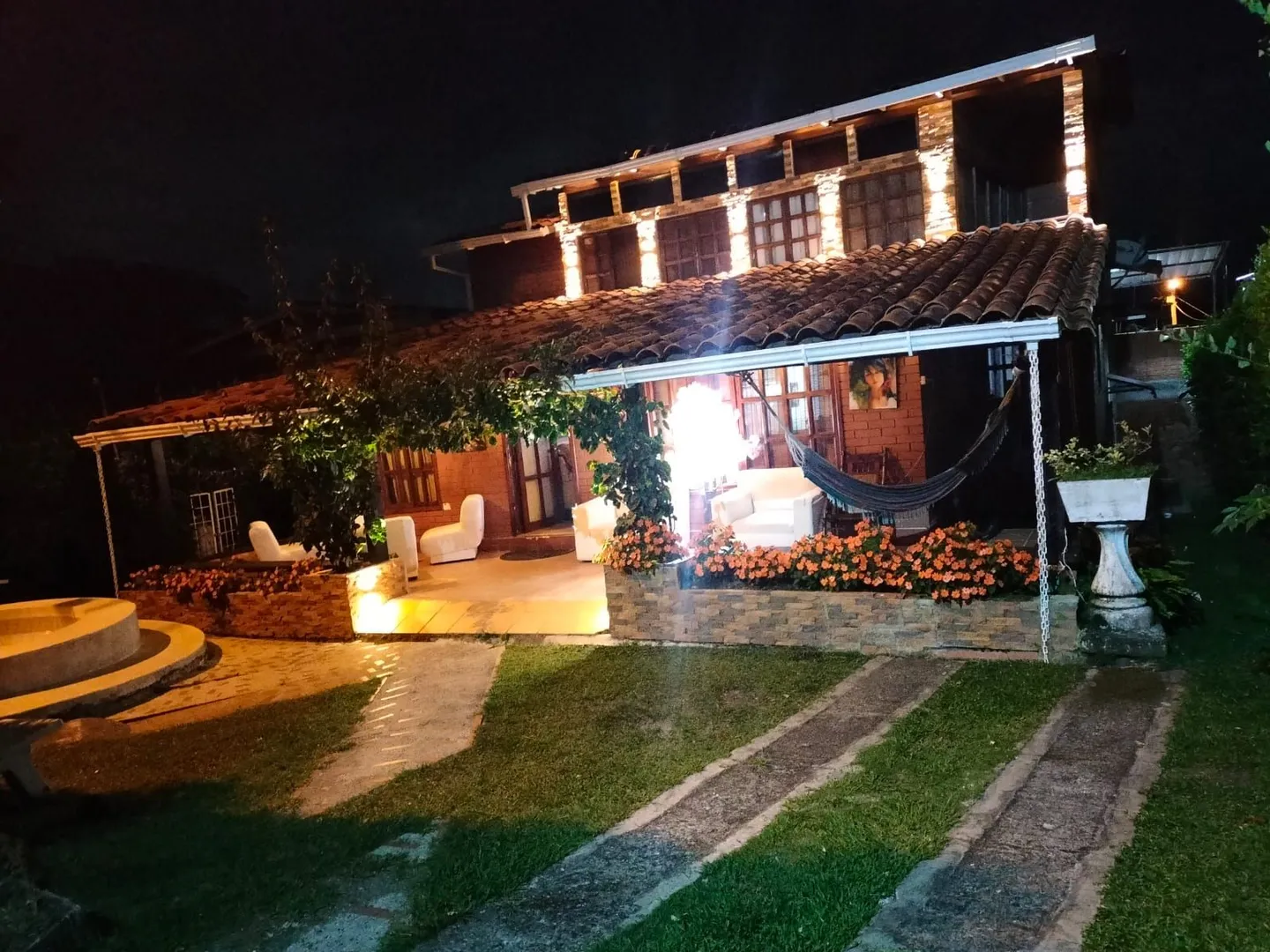 Fachada iluminada del Hostal Campestre El Galeno al anochecer, en Calima El Darién